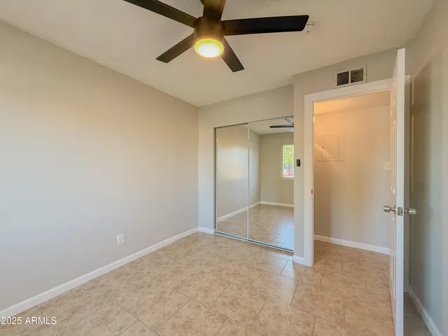 an empty room with fan and entrance