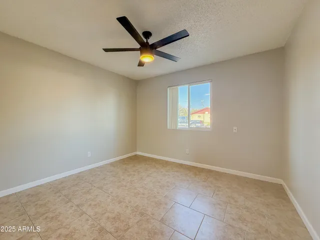 an empty room with a window and a ceiling fan