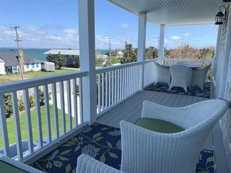 28 Beach Road Oak Bluffs, MA 02557 - Photo 4 of 32 a view of a balcony with chair and wooden floor
