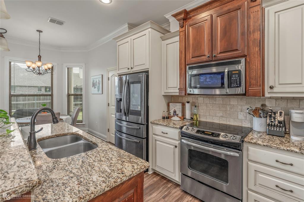 711 Reeds Reef Bossier City, LA 71112 - Photo 13 of 36 a kitchen with granite countertop a stove microwave and refrigerator