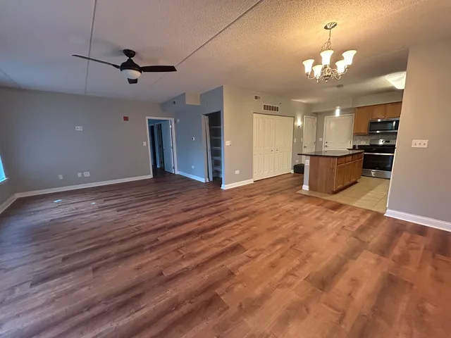 a view of an empty room and kitchen view