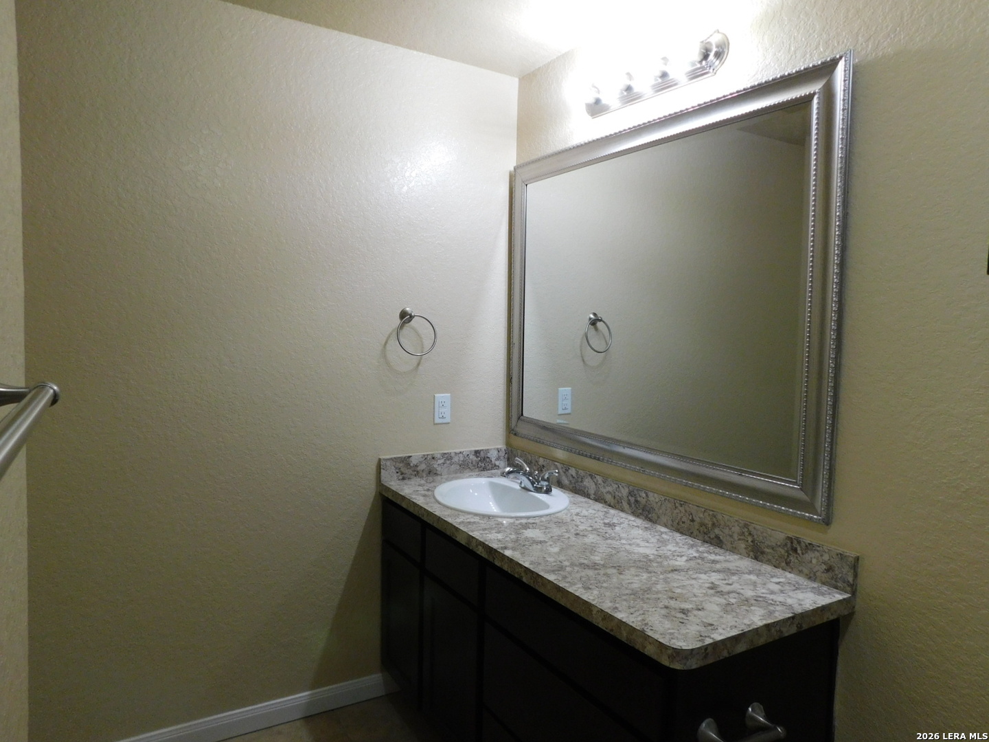 8710 8th Street, Unit 2 Converse, TX 78109 - Photo 13 of 18 a bathroom with a granite countertop sink and mirror