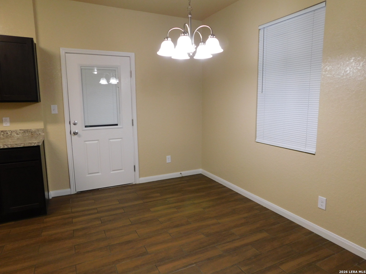 8710 8th Street, Unit 2 Converse, TX 78109 - Photo 3 of 18 an empty room with wooden floor mirror and windows