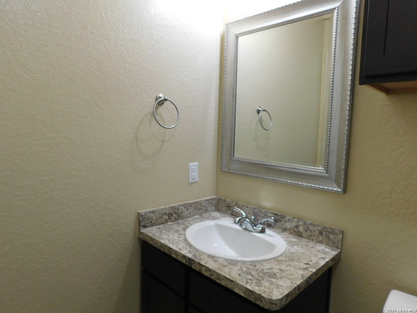 8710 8th Street, Unit 2 Converse, TX 78109 - Photo 9 of 18 a bathroom with a granite countertop sink and a mirror