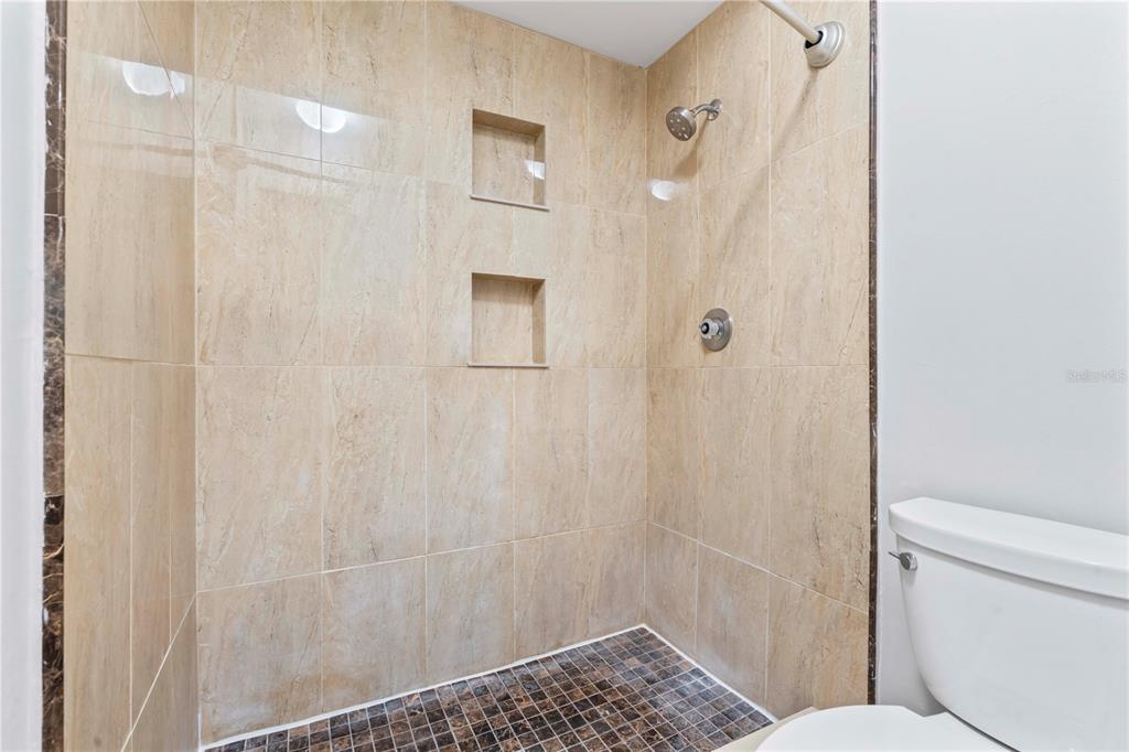 11511 113th Street, Unit 4F Largo, FL 33778 - Photo 23 of 30 a bathroom with a shower and a toilet