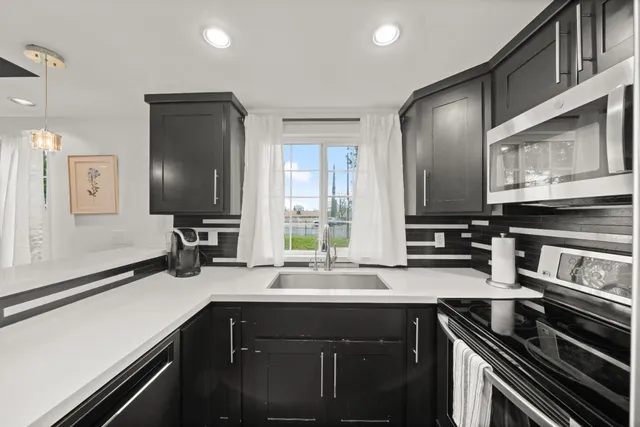 a kitchen with stainless steel appliances a sink and a refrigerator