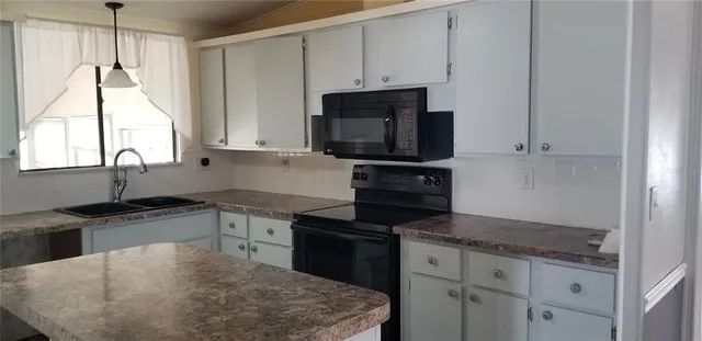 a kitchen with stainless steel appliances granite countertop a sink stove and microwave