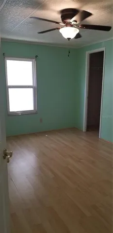 an empty room with a window and a ceiling fan