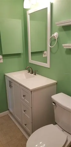 a bathroom with a sink mirror and toilet