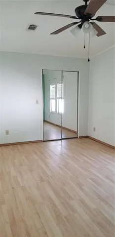 a view of a room with a ceiling fan and a wooden floor