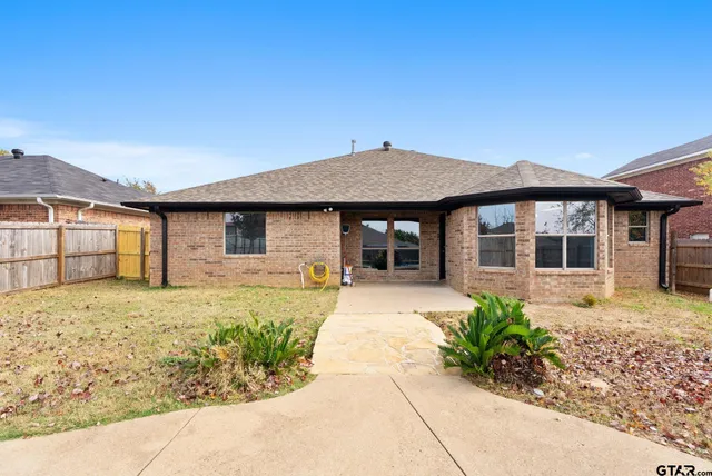 a front view of a house with a garden and patio