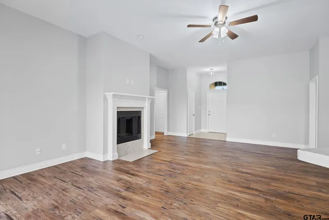 a view of empty room with wooden floor and fireplace