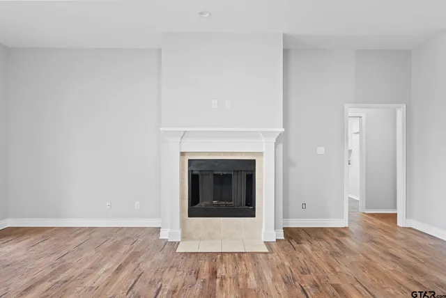 a view of a livingroom with wooden floor and a fireplace