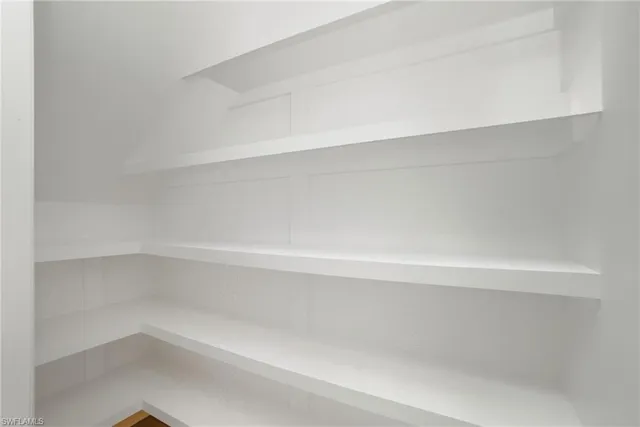 a view of a room with wooden floor and a ceiling fan