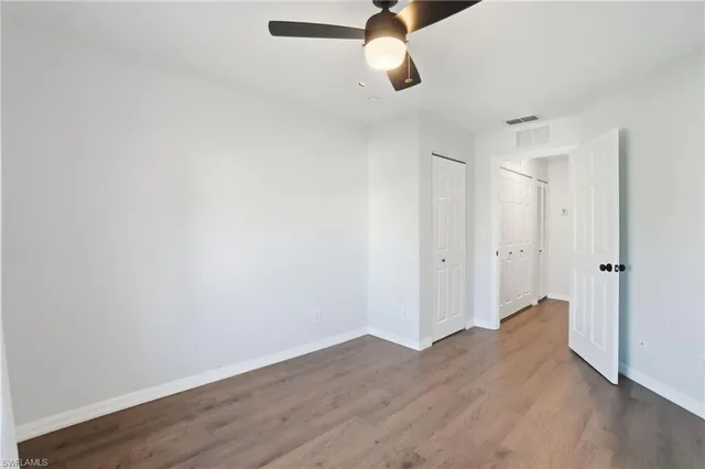 an empty room with windows and closet