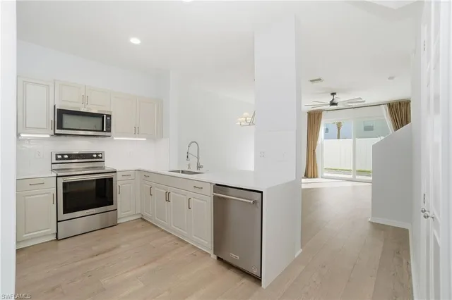 a kitchen with white cabinets and stainless steel appliances
