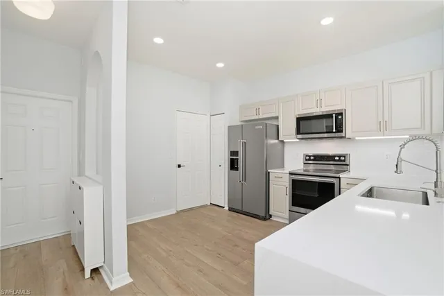 a kitchen with stainless steel appliances white cabinets and a refrigerator