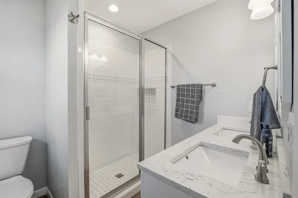 a bathroom with a granite countertop sink toilet and shower