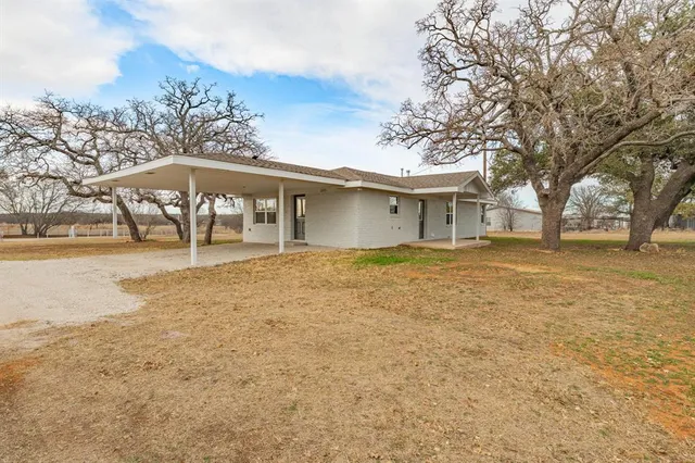 a front view of a house with a yard and trees