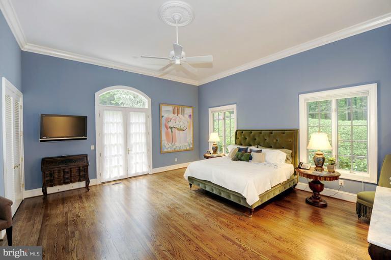 11218 River View Drive Potomac, MD 20854 - Photo 16 of 24 a bedroom with a bed a fireplace and a large window