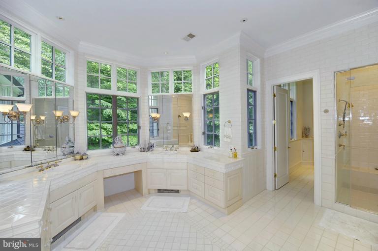 11218 River View Drive Potomac, MD 20854 - Photo 17 of 24 a large white bathroom with a large tub sink shower and mirror