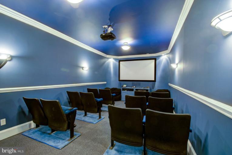 11218 River View Drive Potomac, MD 20854 - Photo 20 of 24 a media room with lots of chairs and a projector screen