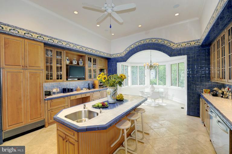 11218 River View Drive Potomac, MD 20854 - Photo 7 of 24 a living room with stainless steel appliances granite countertop furniture a fireplace a flat screen tv and a window