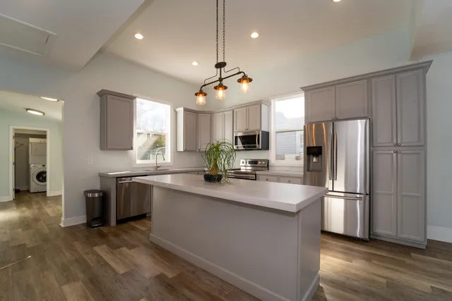 a kitchen with kitchen island a sink stainless steel appliances and counter space