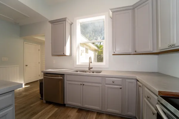 a kitchen with a sink cabinets and wooden floor