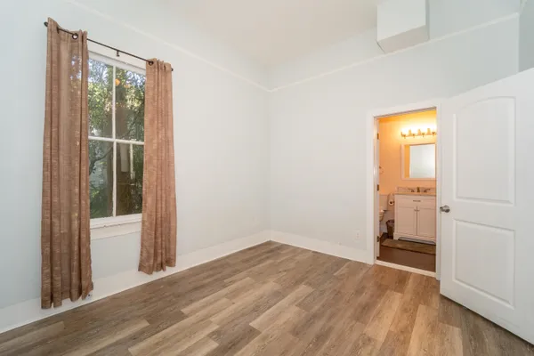 an empty room with wooden floor and a window