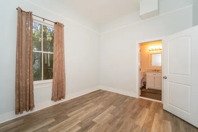 an empty room with wooden floor and a window
