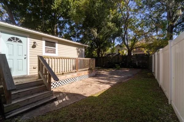 a view of backyard with wooden fence and trees