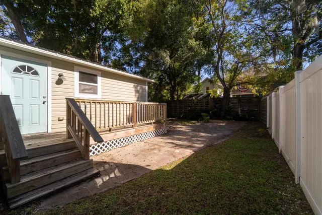 a view of backyard with wooden fence and trees