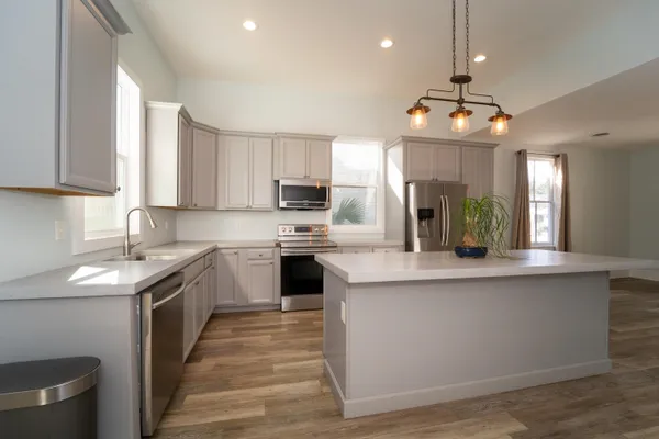 a kitchen with stainless steel appliances granite countertop a sink a stove top oven a counter space and cabinets