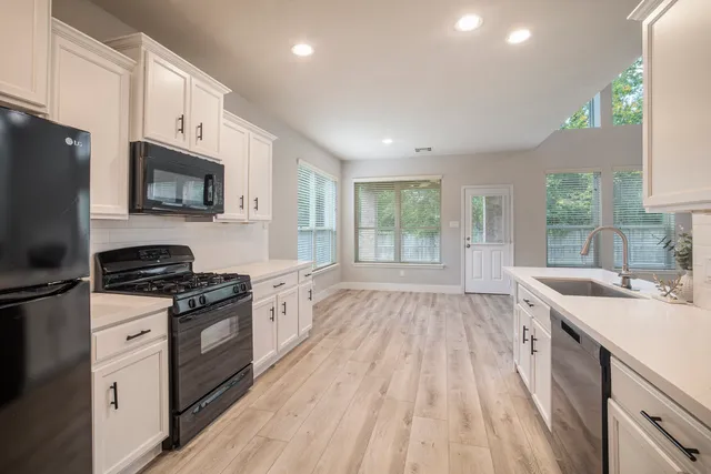 a kitchen with a sink stove top oven and refrigerator