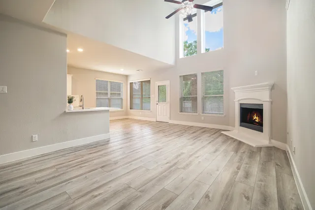 wooden floor fireplace and windows in an empty room
