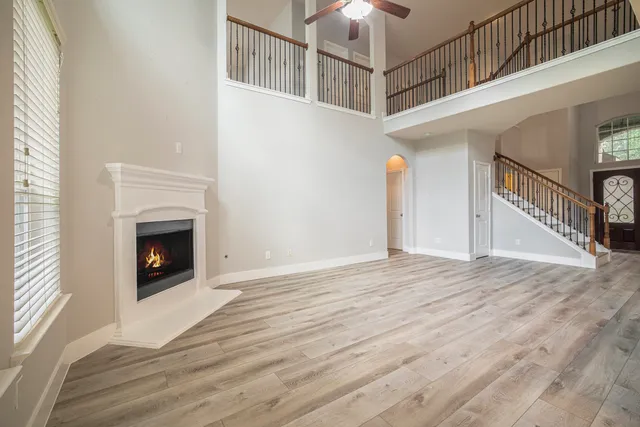 a view of a livingroom with wooden floor a fireplace and entryway