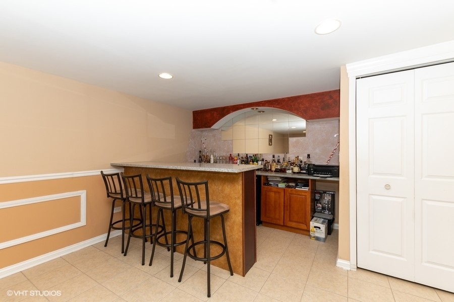 2605 West 83rd Place Chicago, IL 60652 - Photo 11 of 14 a kitchen with stainless steel appliances kitchen island granite countertop a stove a sink and a refrigerator with wooden floor