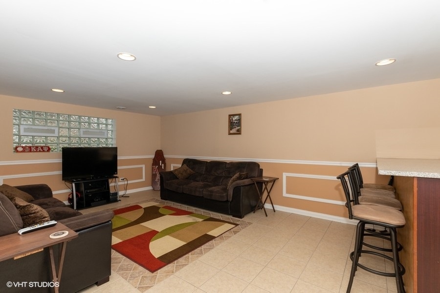 2605 West 83rd Place Chicago, IL 60652 - Photo 12 of 14 a living room with furniture and a flat screen tv
