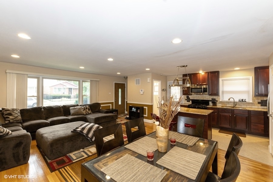 2605 West 83rd Place Chicago, IL 60652 - Photo 3 of 14 a living room with furniture a flat screen tv and kitchen view
