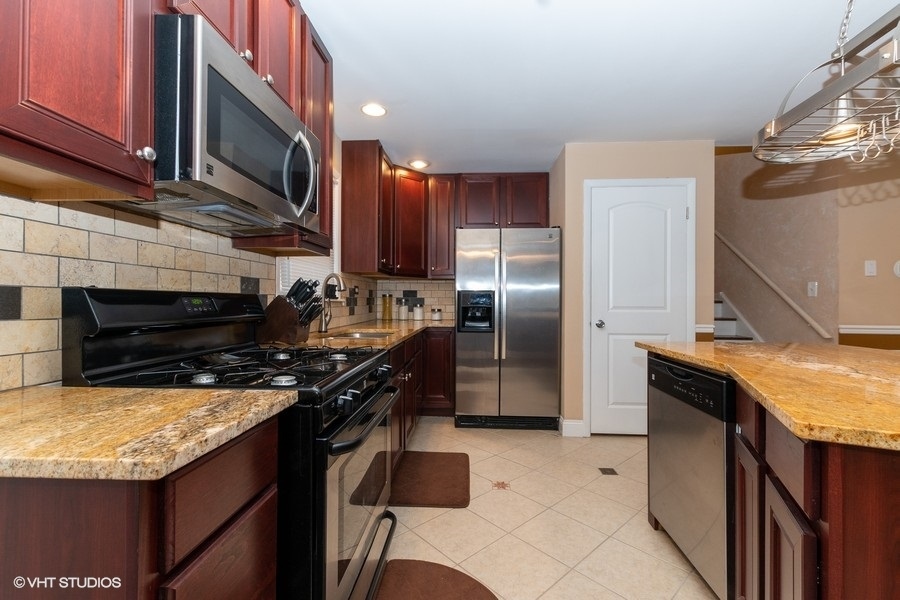 2605 West 83rd Place Chicago, IL 60652 - Photo 4 of 14 a kitchen with stainless steel appliances granite countertop a stove refrigerator sink and microwave