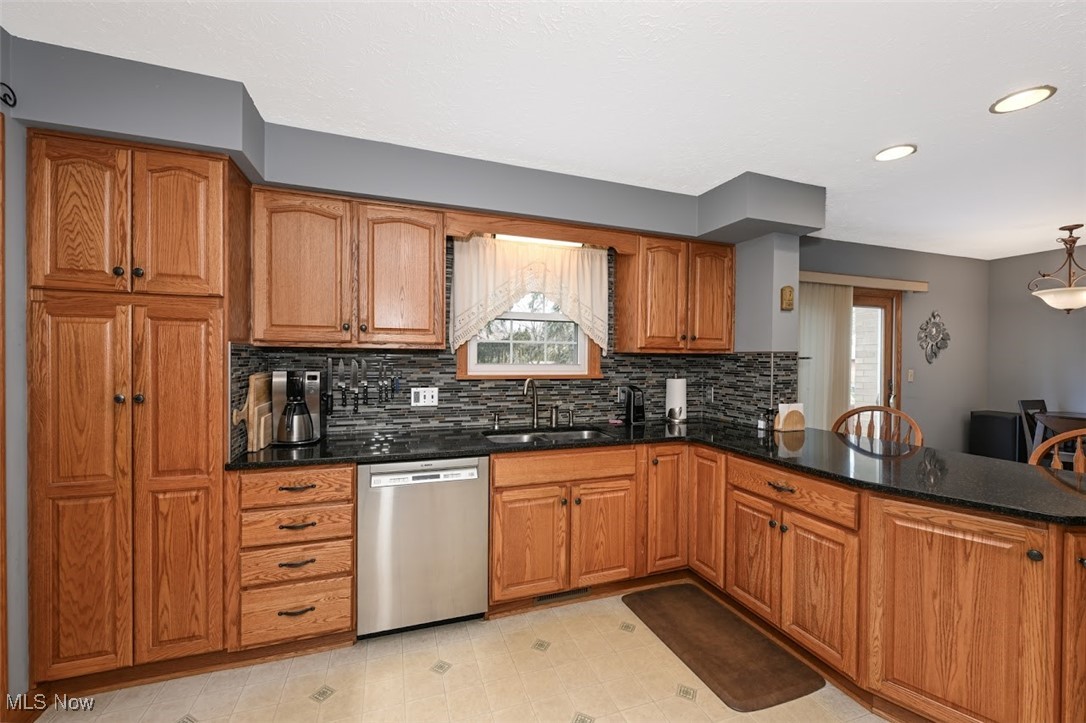 3305 Edington Road Akron, OH 44333 - Photo 13 of 46 Kitchen featuring dishwasher, brown cabinetry, a wealth of natural light, and a sink