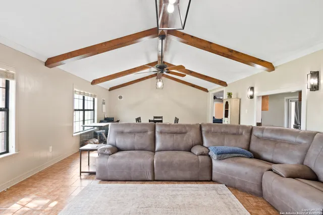 a living room with furniture and a ceiling fan