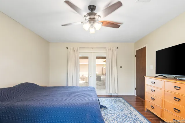 a bedroom with a bed and flat tv screen on the dresser