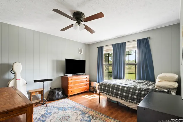 a bedroom with a bed and wooden floor