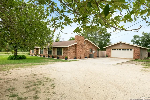 a front view of a house with a yard and trees