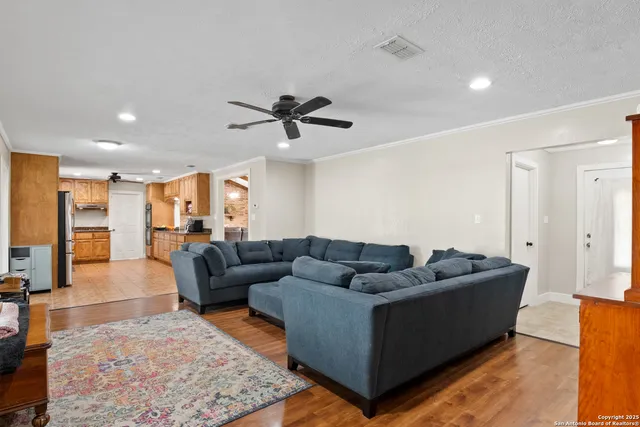 a living room with furniture and a view of kitchen