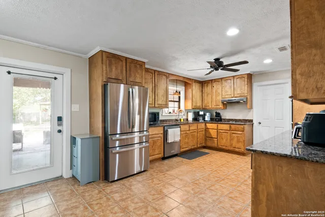 a kitchen with stainless steel appliances granite countertop a refrigerator a stove a sink and a refrigerator