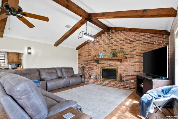 a living room with furniture a flat screen tv and a fireplace