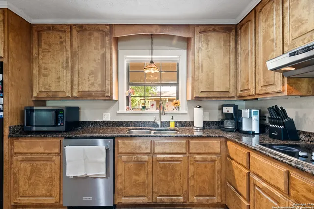 a kitchen with stainless steel appliances granite countertop a sink a stove and cabinets